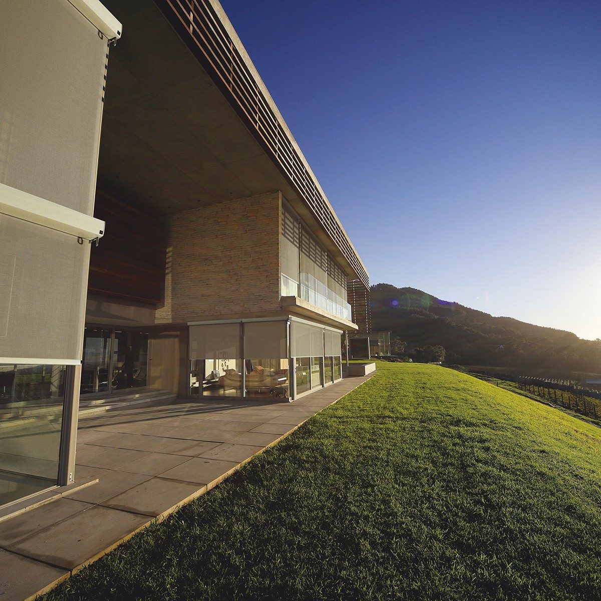 alpha external drop screens on a building with sunset, grass fields