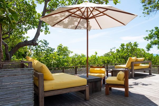 Large outdoor umbrella on patio deck with sunny sky in background